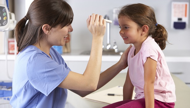 Nurse examining child during check up